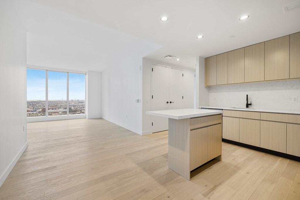 a living room with a kitchen and a window at The Paxton, Brooklyn, New York